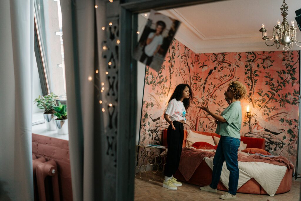 Mother and daughter standing in a bedroom having a tense conversation, symbolizing struggles before healing from a narcissistic mother.