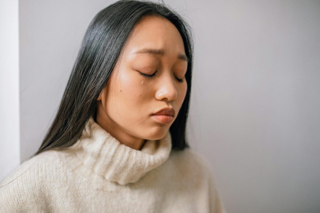 A woman with tears in her eyes, symbolizing the guilt and emotional weight of going no contact with a narcissistic mother.