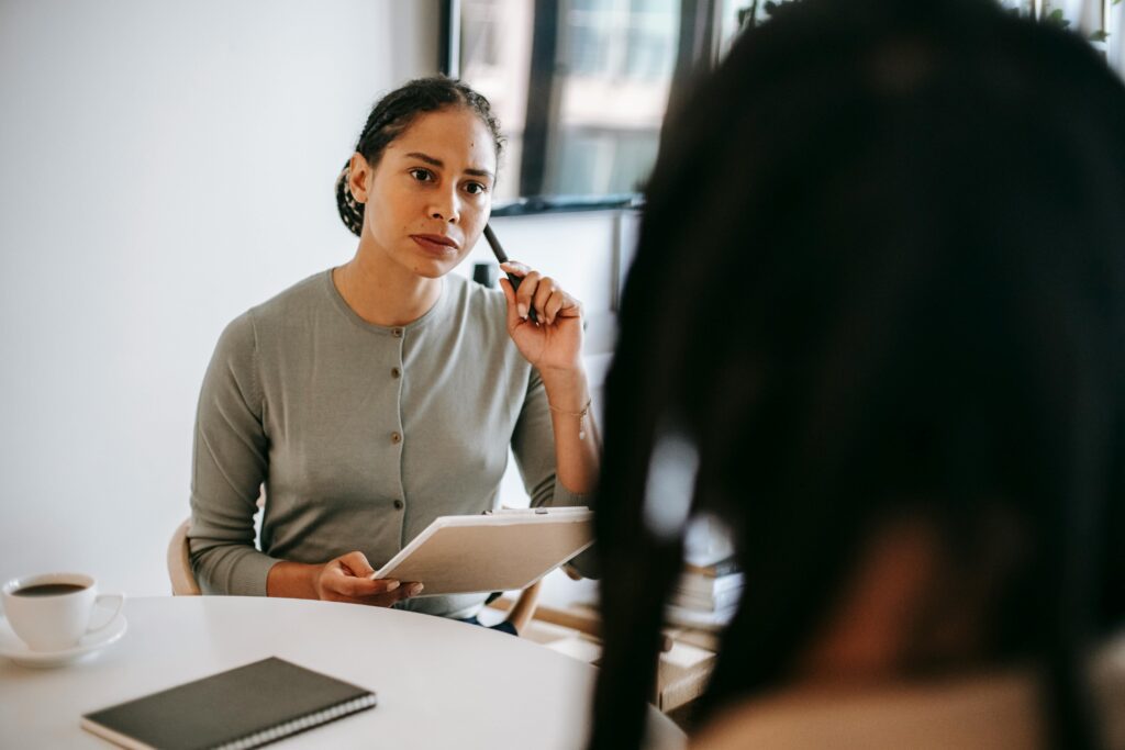 A therapist attentively listening to a client, symbolizing the importance of therapy in setting boundaries with a narcissistic mother.